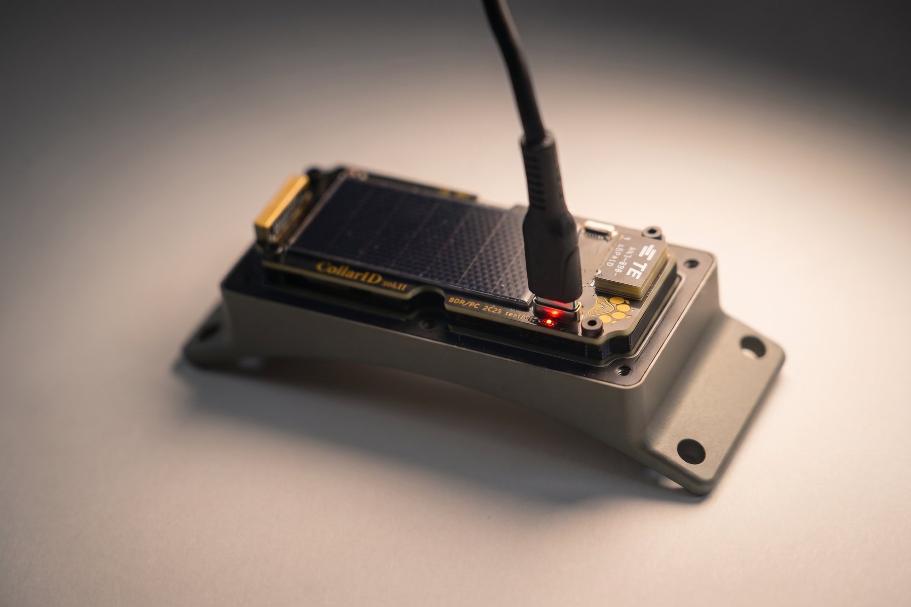 Close-up of the charge LED area showing the red LED illuminated while charging