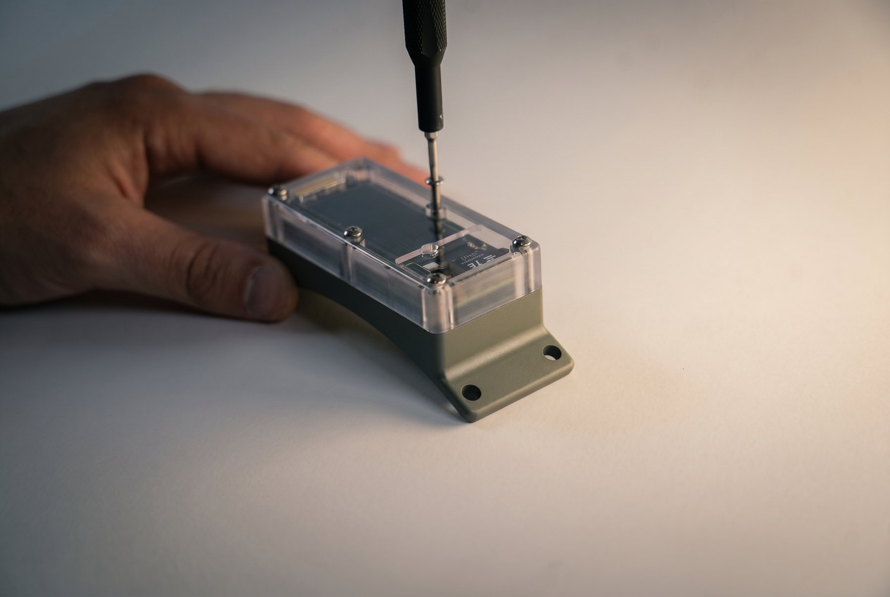Cover screws being actively backed out with a hex driver
